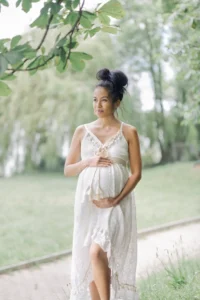 photo d'une maman enceinte portant son ventre dans un parc lors d'une séance photo avec Tiana Photographe Toulouse