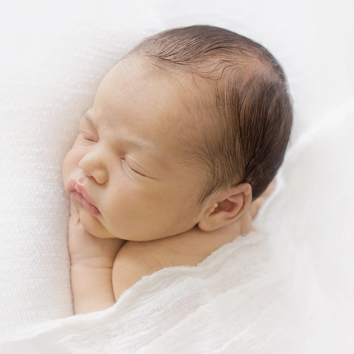Photo d'un nouveau né qui dort lors d'une séance photo avec Tiana Photographe naissance Toulouse
