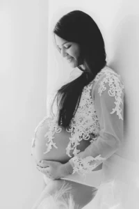 Photo d'une future maman appuyer sur le mur regardant son ventre lors d'un shooting grossesse avec Tiana Photographe Toulouse