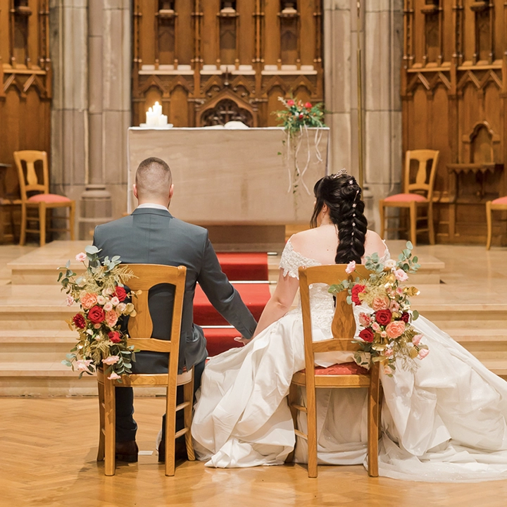 Photo d'un couple marié à l'église assise devant l'hotel.