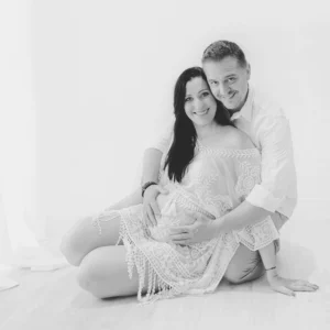 Photo d'un couple assise côte à côte lors d'une séance grossesse avec Tiana Photographe Toulouse