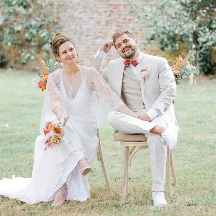 Photo de couple sur leur chaise lors de leur cérémonie laïque à L'Abbaye des Nizelles en Belgique. Reportage de mariage par Tiana Photographe Toulouse