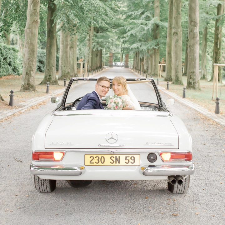 Photo de couple de mariés dans une décapotable au château du Biez en Belgique