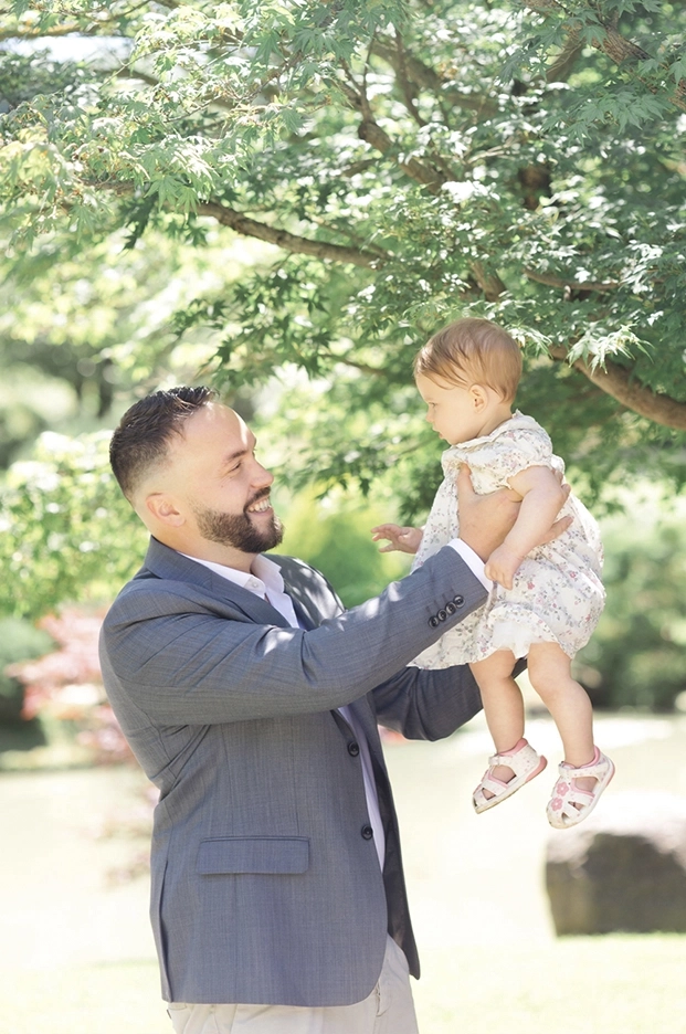 Photo de famille d'un papa qui tient sa fille en l'air au jardin japonais à Toulouse